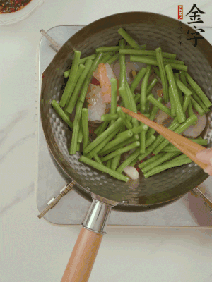 下掰好的缸豆段翻炒，略燜煮。