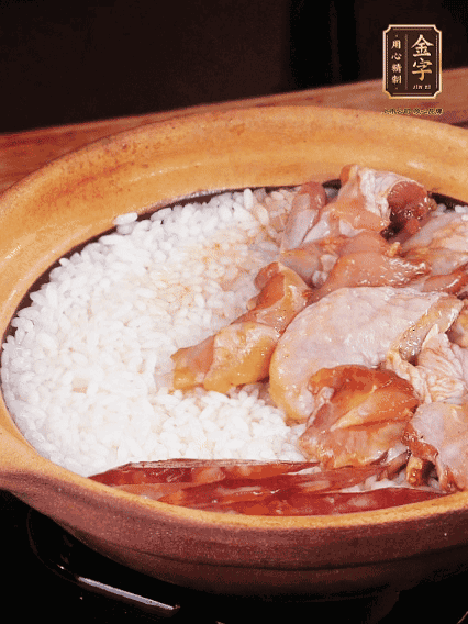 煮到椰子水微微收干轉(zhuǎn)小火，快速均勻鋪上雞肉、金字香腸