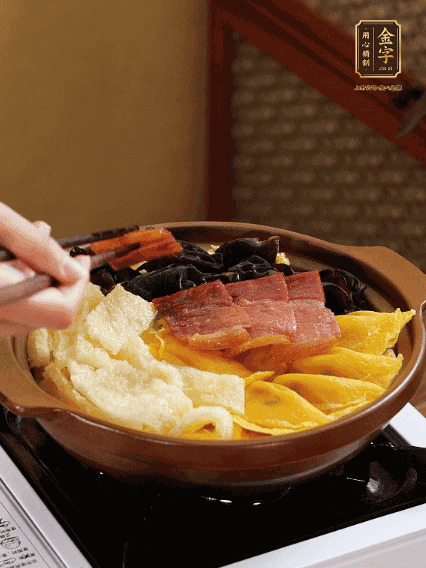 砂鍋底部鋪上娃娃菜，依次擺上肉皮、蛋餃、黑木耳、火腿